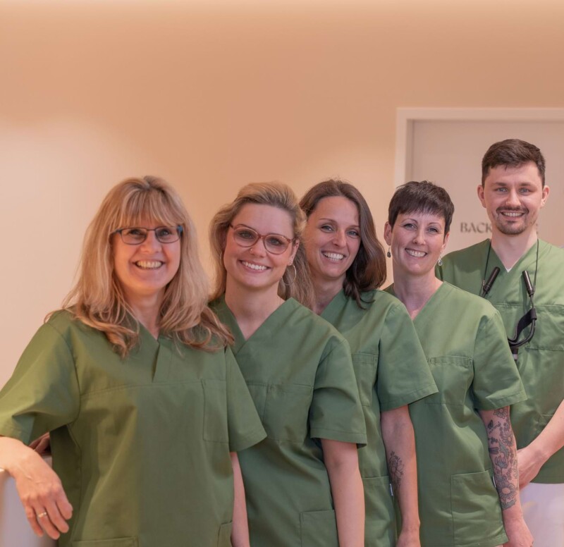 Fotoaufnahme: Team steht aufgereiht und schaut in die Kamera